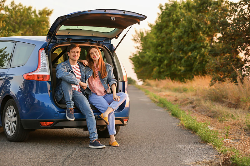 Couple sitting in the back of a hatchback car
